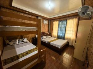 een slaapkamer met 2 stapelbedden en een ventilator bij SILVERISE Pension in El Nido +3 foto's