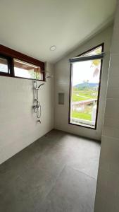an empty bathroom with a shower and a window at Sumator Resort Chiangrai สูมาเต๊อะ รีสอร์ท เชียงราย in Ban Huai Phaya Kao