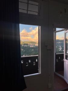 a window in a room with a view of a city at The Southside Den in Āīzawl