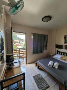 een slaapkamer met een bed en een tafel en een balkon bij SILVERISE Pension in El Nido