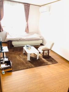 een woonkamer met een bed en een salontafel bij れのん in Okazaki +9 foto's