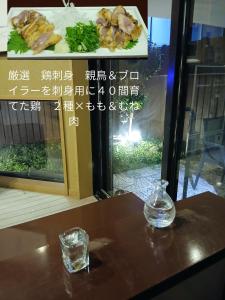 einen Tisch mit einem Glas Wasser und einem Teller mit Lebensmitteln in der Unterkunft れのん in Okazaki + 5 Fotos