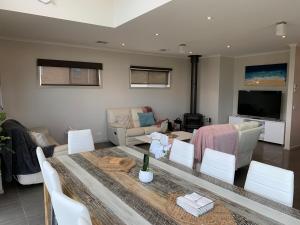 a living room with a table and chairs and a television at Large Five Bdrm Home Near Beach in Apollo Bay
