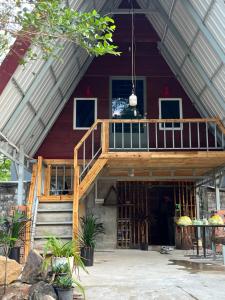 a house with a wooden deck in front of it at Private home in Kampot