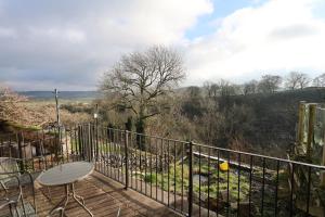 a deck with a table and a chair on a balcony at Dale View in Youlgreave