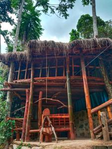 a bamboo house with a thatched roof at River cottage Demodara in Demodera