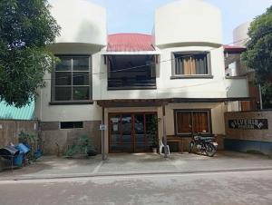 een groot wit huis met een bord ervoor bij SILVERISE Pension in El Nido