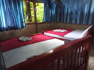 two twin beds in a room withthritisthritisthritisthritisthritisthritisthritisthritisthritis at River cottage Demodara in Demodera