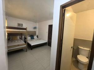 een kleine kamer met 2 stapelbedden en een toilet bij SILVERISE Pension in El Nido