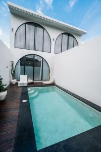 a swimming pool in front of a house at Modern 1BR Loft style with pool in Pegending in Dalung