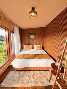 een slaapkamer met een bed en een groot raam bij Chewavethee Herb Wellness Stay in Ban Chae Phang (1)