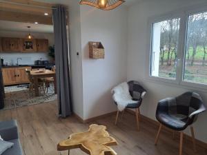 a living room with two chairs and a table at La maison d'à côté in Desingy