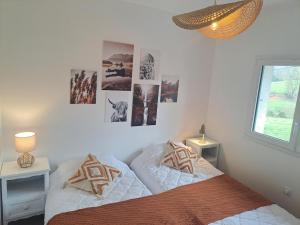a bedroom with two beds and pictures on the wall at La maison d'à côté in Desingy +25 photos