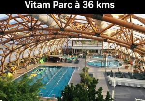 a large indoor swimming pool in a building at La maison d'à côté in Desingy