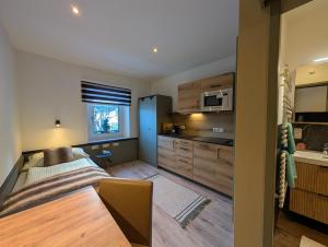 a kitchen with wooden cabinets and a table in a room at Hotel Apartment Das Au- Gut in Hallein