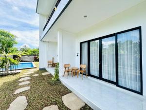 a patio with a table and chairs next to a house at Chevana House Jimbaran in Jimbaran