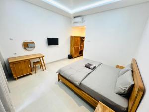 a bedroom with a bed and a desk at Chevana House Jimbaran in Jimbaran