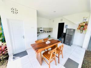 a kitchen with a wooden table and chairs at Chevana House Jimbaran in Jimbaran