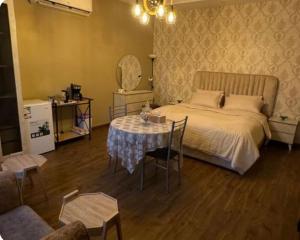 a bedroom with a bed and a table with chairs at جدة حي الرياض in Quai