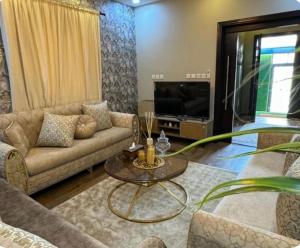 a living room with a couch and a tv at جدة حي الرياض in Quai