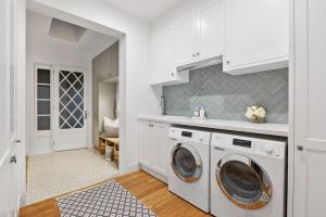 a kitchen with white cabinets and a washer and dryer at Coastal Luxe - Hampton inspired in Kingscliff