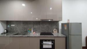a kitchen with a sink and a refrigerator at Capsule Masterise Vinhomes in Gia Lâm Pho