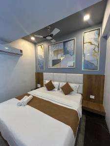 a bedroom with two beds and a ceiling fan at Hotel secure inn saroli in Surat +7 photos