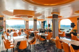 a restaurant with orange chairs and tables and windows at Sun Heaven Dalat in Xuân Trường