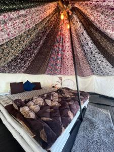 un letto in una camera con baldacchino di Zelten Bir Eco Camp's & Cafe a Bīr