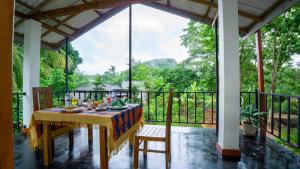 a dining room with a table and chairs on a balcony at Isuru Homestay Pidurangala in Sigiriya