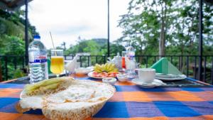 a table with a plate of bread and a bottle of water at Isuru Homestay Pidurangala in Sigiriya +33 photos