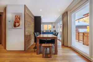 a dining room with a wooden table and chairs at Cornelia 1 Ski-In-Out Stunning Views & Sleeps 8 in Saas-Fee