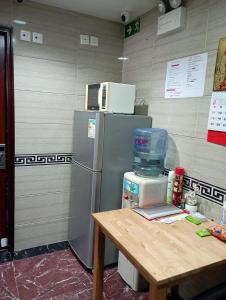 a kitchen with a refrigerator and a wooden table at Everest Base Cam Hostel in Hong Kong