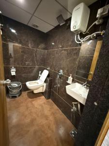 a bathroom with a toilet and a sink at Hotel secure inn saroli in Surat