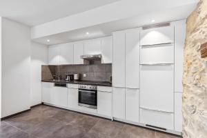a white kitchen with white cabinets and appliances at The R Apartment Rosengasse in Schaffhausen
