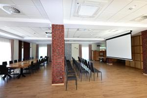 a conference room with tables and chairs and a brick pillar at Stay at Royal Kraków Golf in Ochmanów