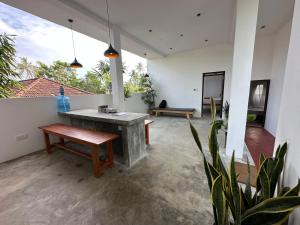 a living room with a bench and a table at Bamboo Garden Inn in Goiyapana