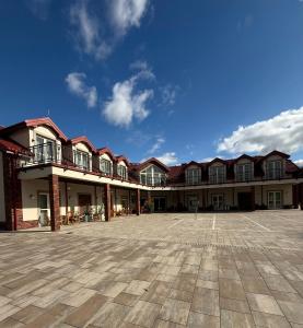 a large building with a courtyard in front of it at Stay at Royal Kraków Golf in Ochmanów