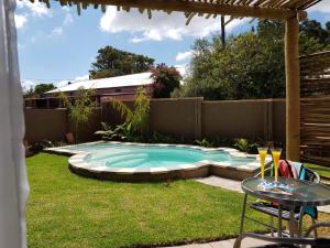 a small swimming pool in a yard with a table at Absolute Castillo in Riebeek-Kasteel