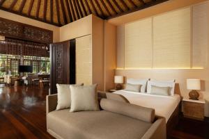 a bedroom with a bed and a couch at Villa Leona Ubud in Ubud