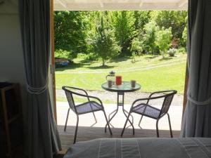a table and two chairs in front of a window at Okuti Country Cottage, a private and peaceful retreat in Little River