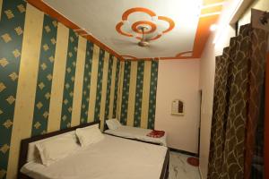 a small room with a bed and a ceiling at Sabri Palace Ayodhya in Ayodhya