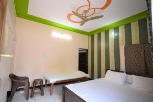 a room with two beds and a ceiling fan at Sabri Palace Ayodhya in Ayodhya