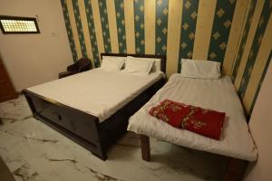 two twin beds in a room with at Sabri Palace Ayodhya in Ayodhya +3 photos