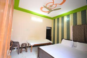a room with two beds and a ceiling fan at Sabri Palace Ayodhya in Ayodhya