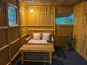 a wooden room with a bench and a table in it at Dodo's Bamboo Resort in Rāja Māyang