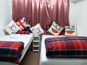 two beds in a room with british flag pillows at Payless A2 Guest House in Hong Kong