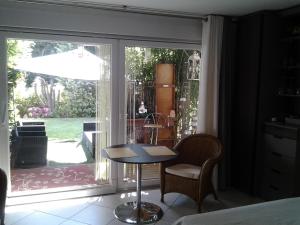 a room with a table and chairs in front of a window at Les 3 Clés in Dossenheim-Kochersberg