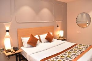a bedroom with a large bed and a mirror at Qotel Comfort Golden Saffron - Hotel in Punjabi Bagh Near Metro in New Delhi +75 photos