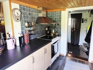 a kitchen with a sink and a stove top oven at Charming red cottage in Vaderstad SE10024 in Väderstad